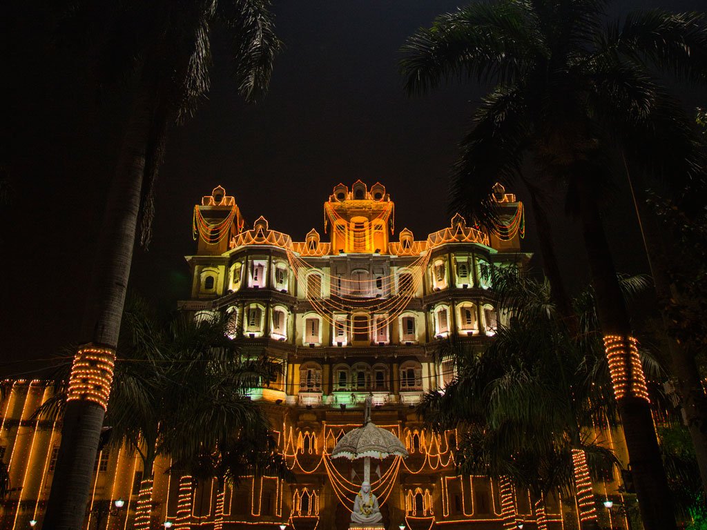 New York City skyline at twilight featuring the Empire State Building and other skyscrapers illuminated against a purple-blue sky.