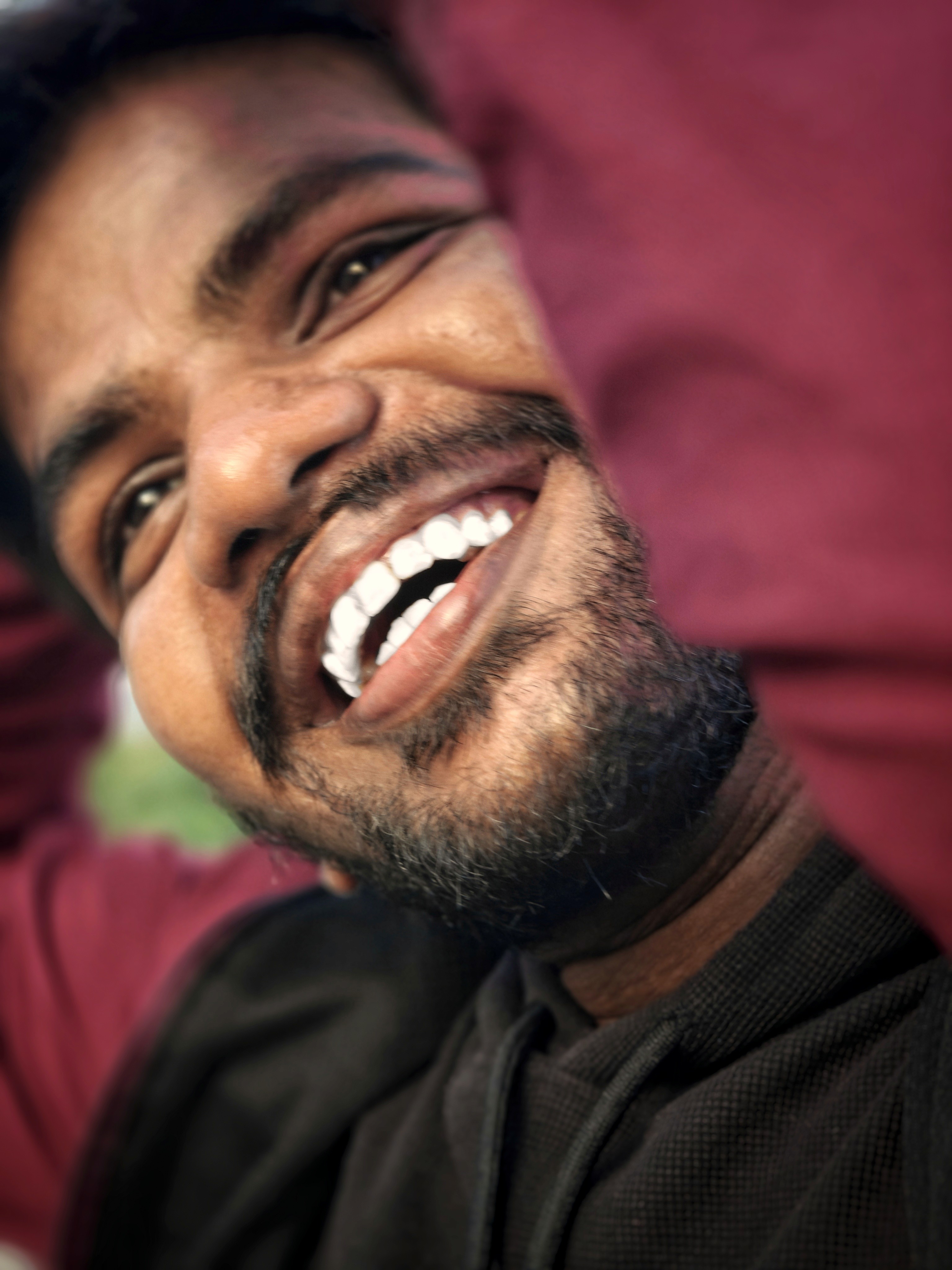Green car under neon lights in a rainy city street