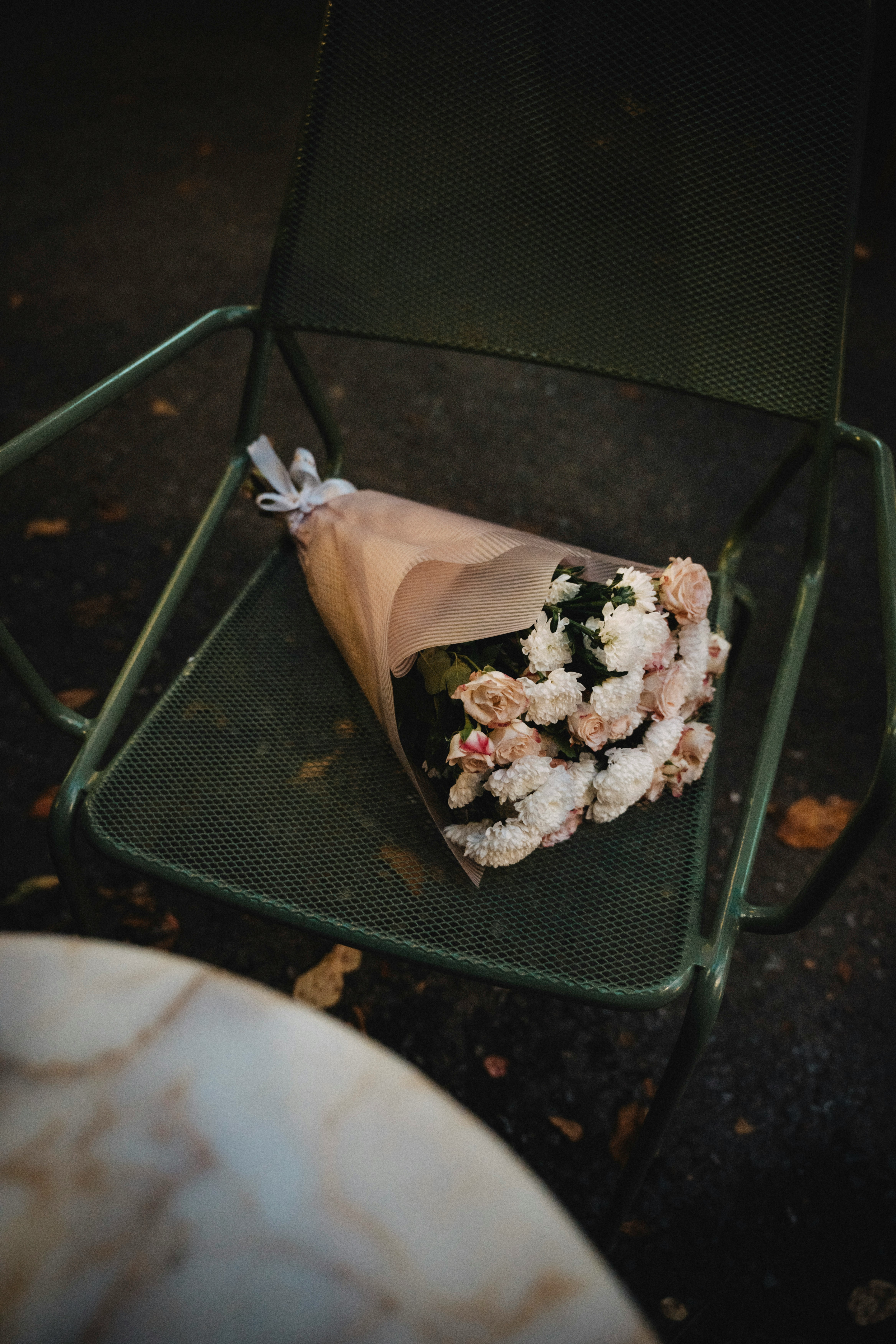Bouquet of flowers resting on a green chair.