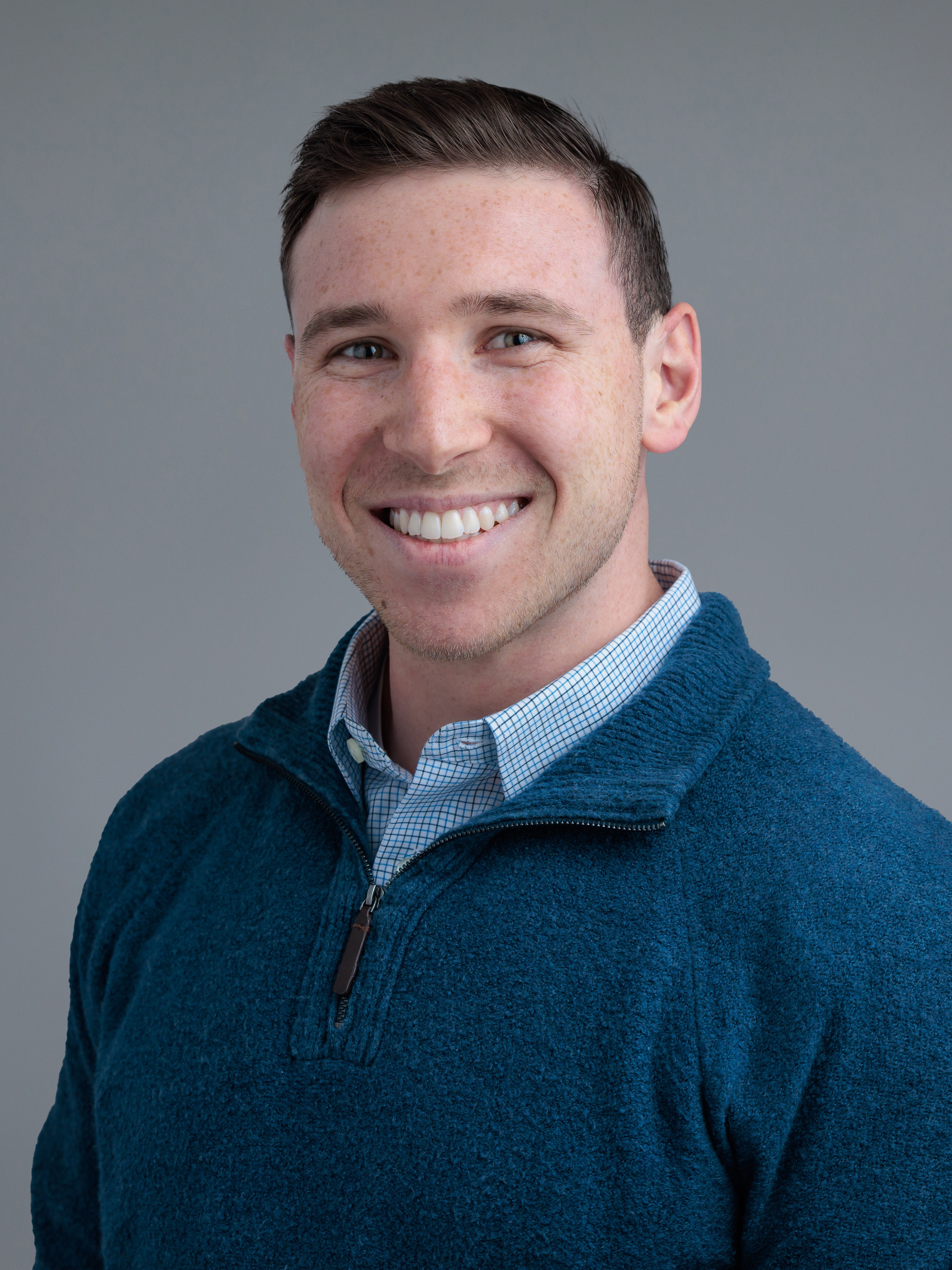 Headshot of a man in a blue sweater