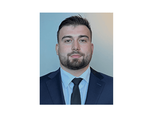 Tall modern skyscraper with vertical lines, viewed against a clear blue sky.