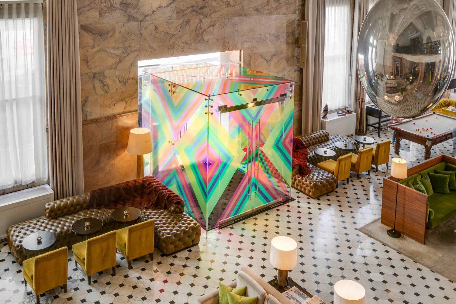 A boutique interior with a geometric wall art display, gold shelving, and luxurious decor in a marble-floored space.