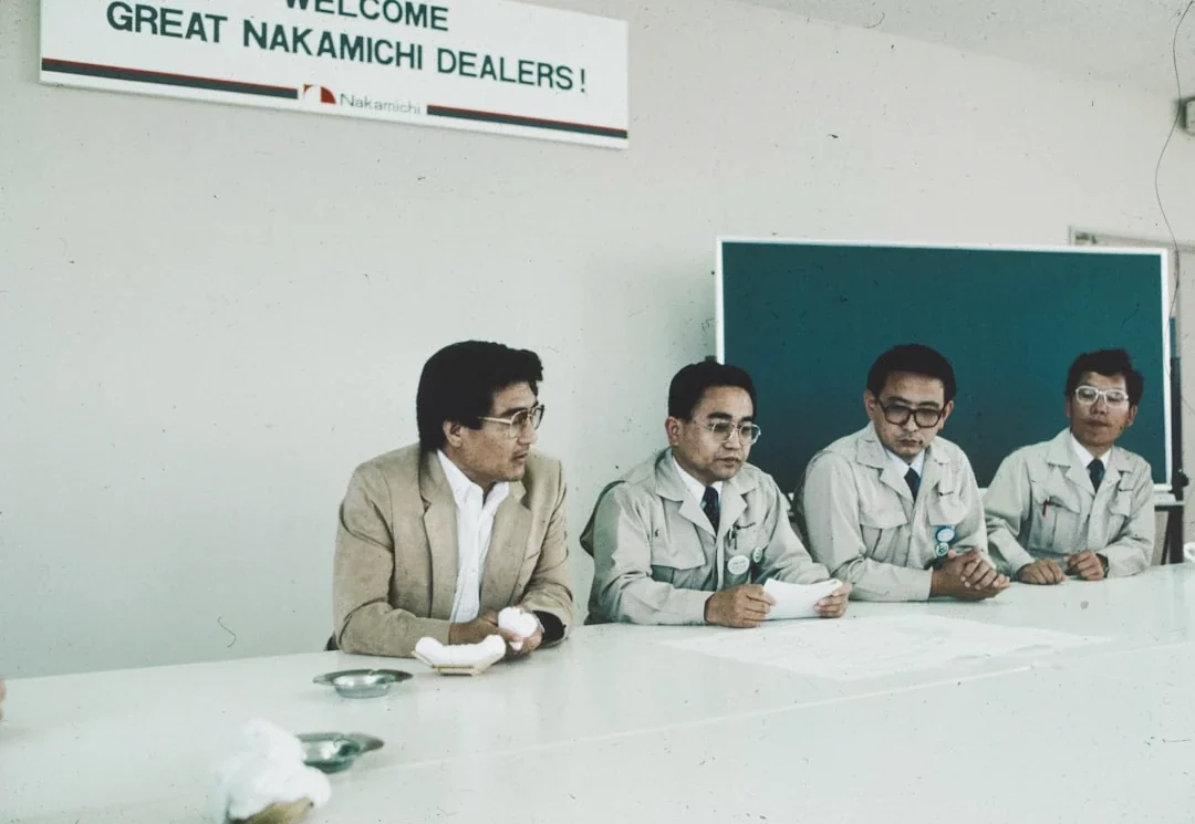 A group of men sitting around a white table