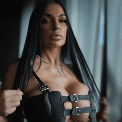 Mujer con disfraz estilo simbionte posando frente a una pared, destacando detalles oscuros y llamativos en su atuendo.