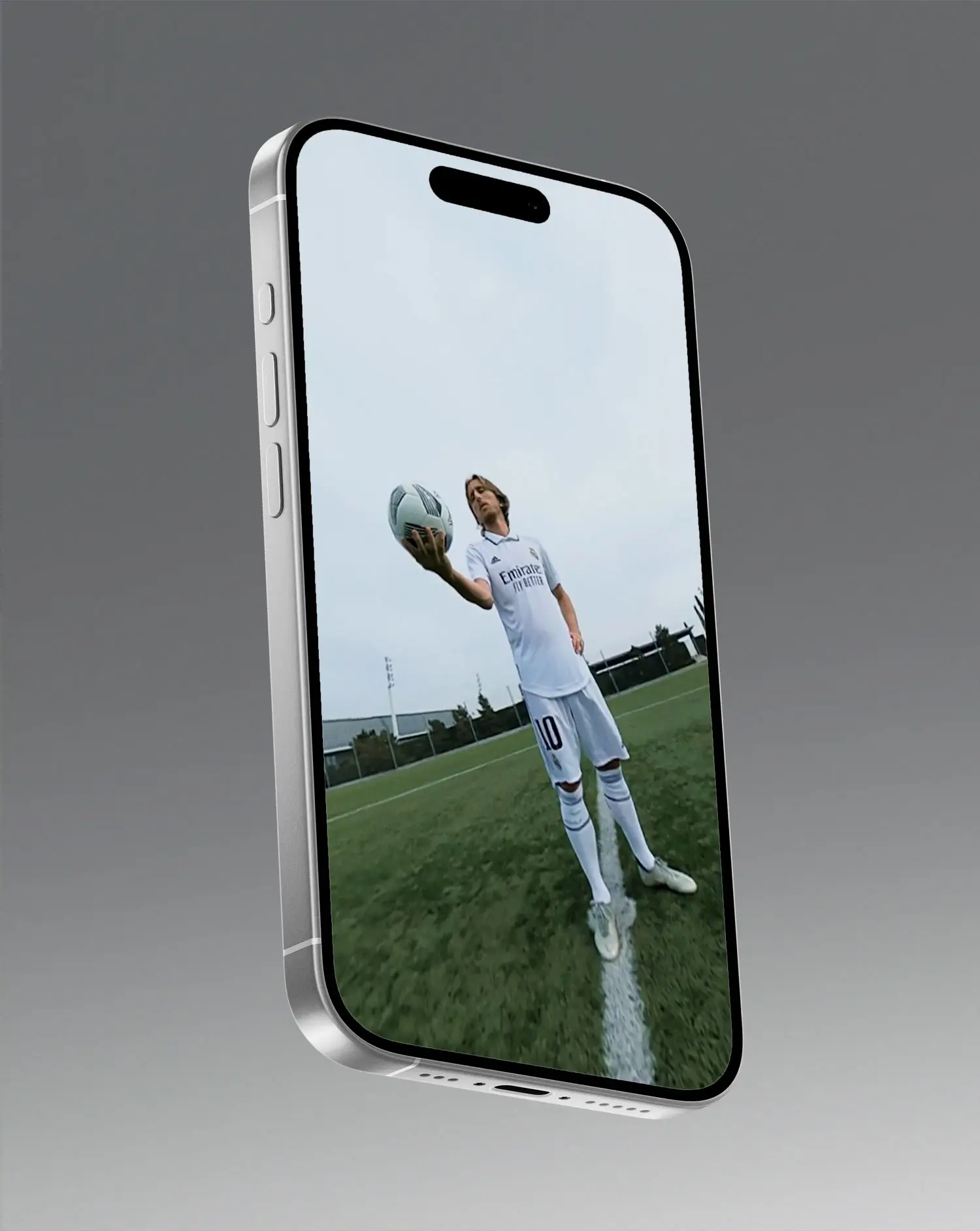 Portfolio Thankium: Smartphone mostrando a Modric en campo de fútbol en el campo con balón, pantalla en ángulo.