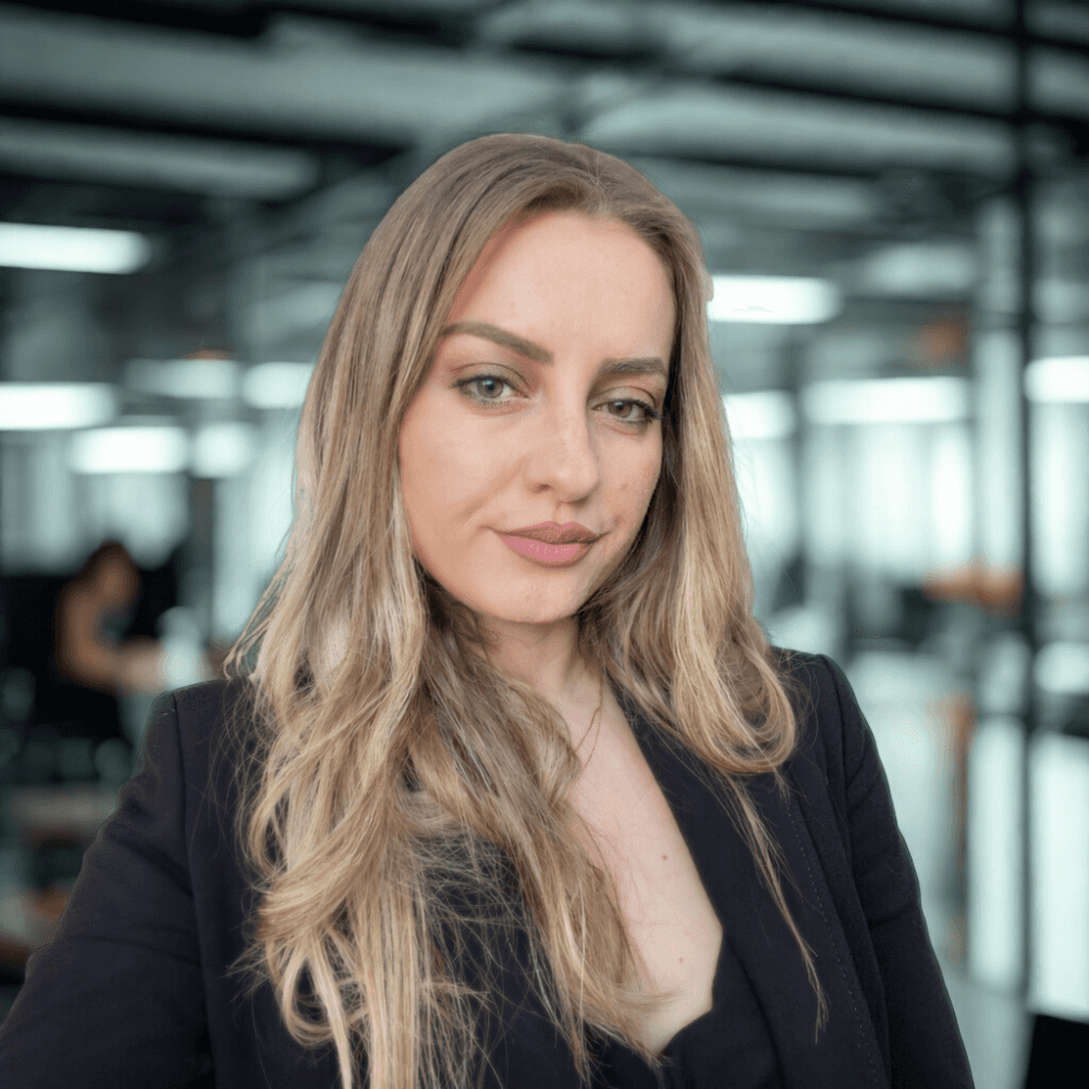 person in blue shirt writing on white paper