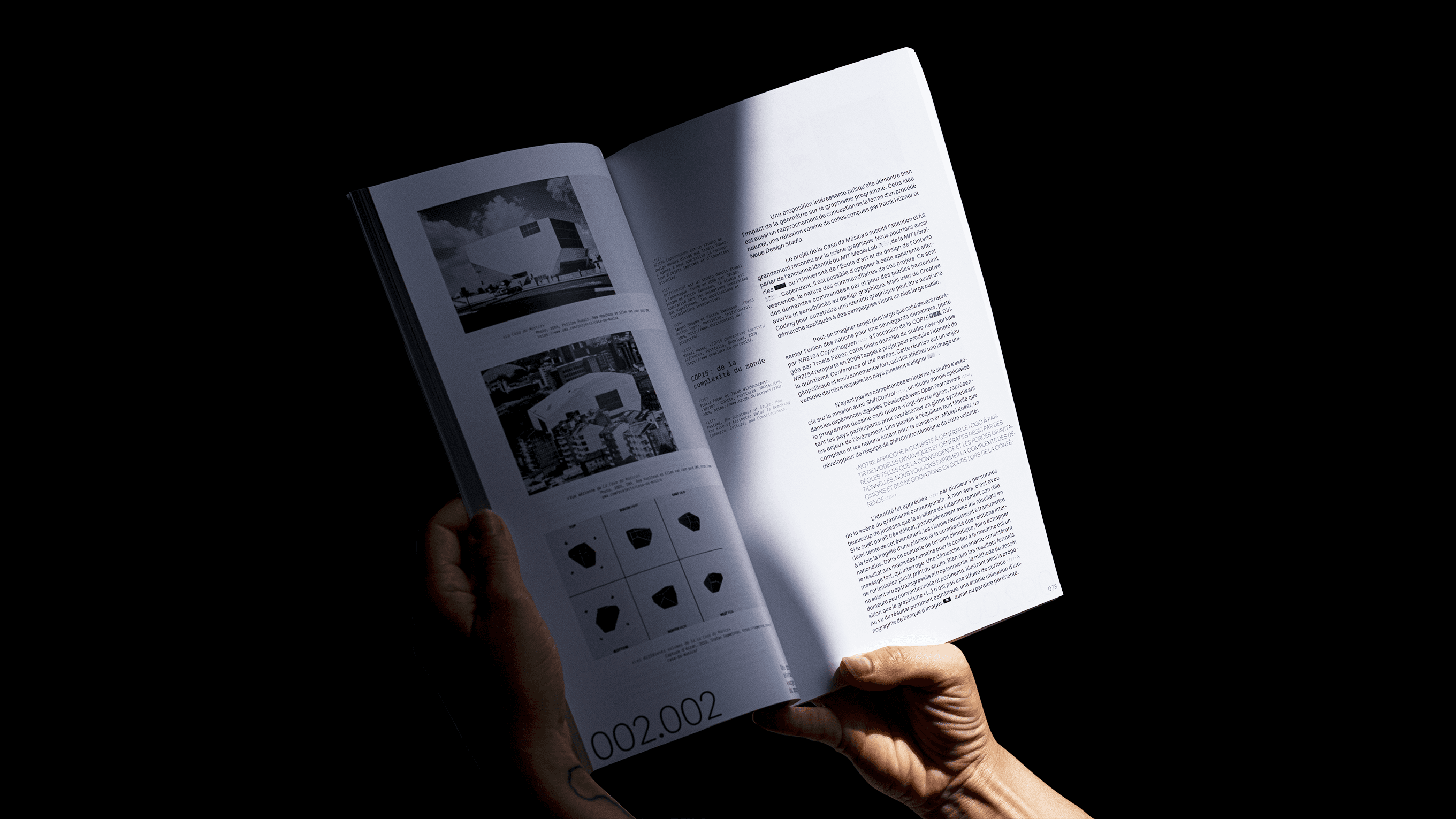 Book spread with black and white photography, diagrams, and explanatory text, held open in natural light
