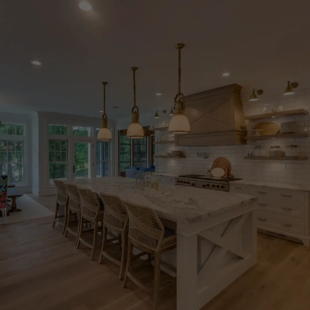 Modern farmhouse-style kitchen featuring a large white marble island with wooden X-paneling, wicker barstools, brass pendant lights, white subway tile backsplash, and open wooden shelving—expertly renovated by B&Y Reno Corp.