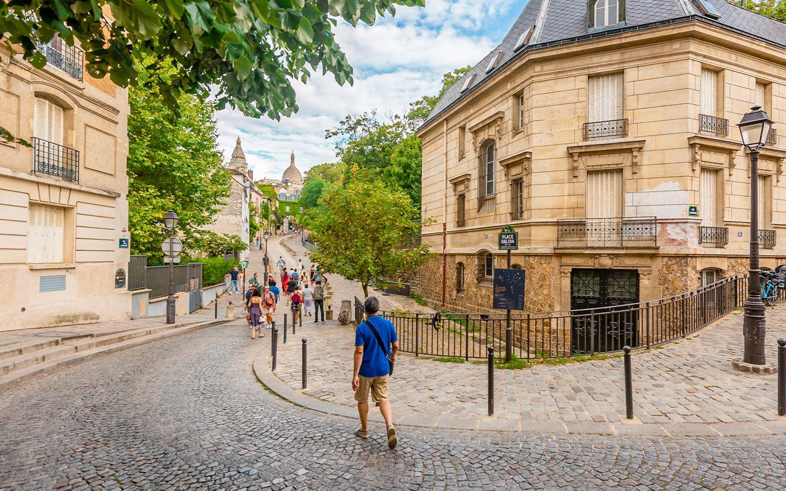 Mga turista na naglalakad sa mga kalsadang bato sa Montmartre, Paris kasama ang mga makasaysayang gusali.