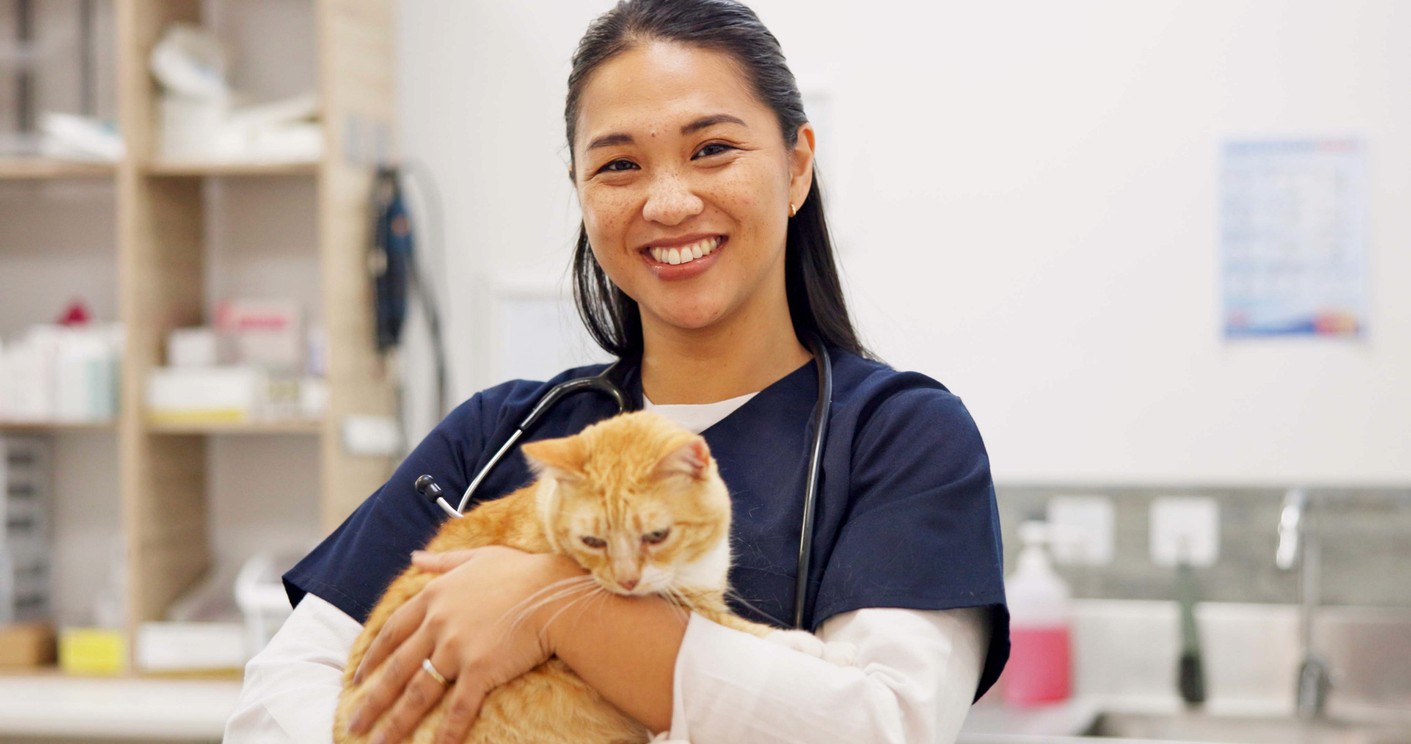 asian woman vet hugging cat