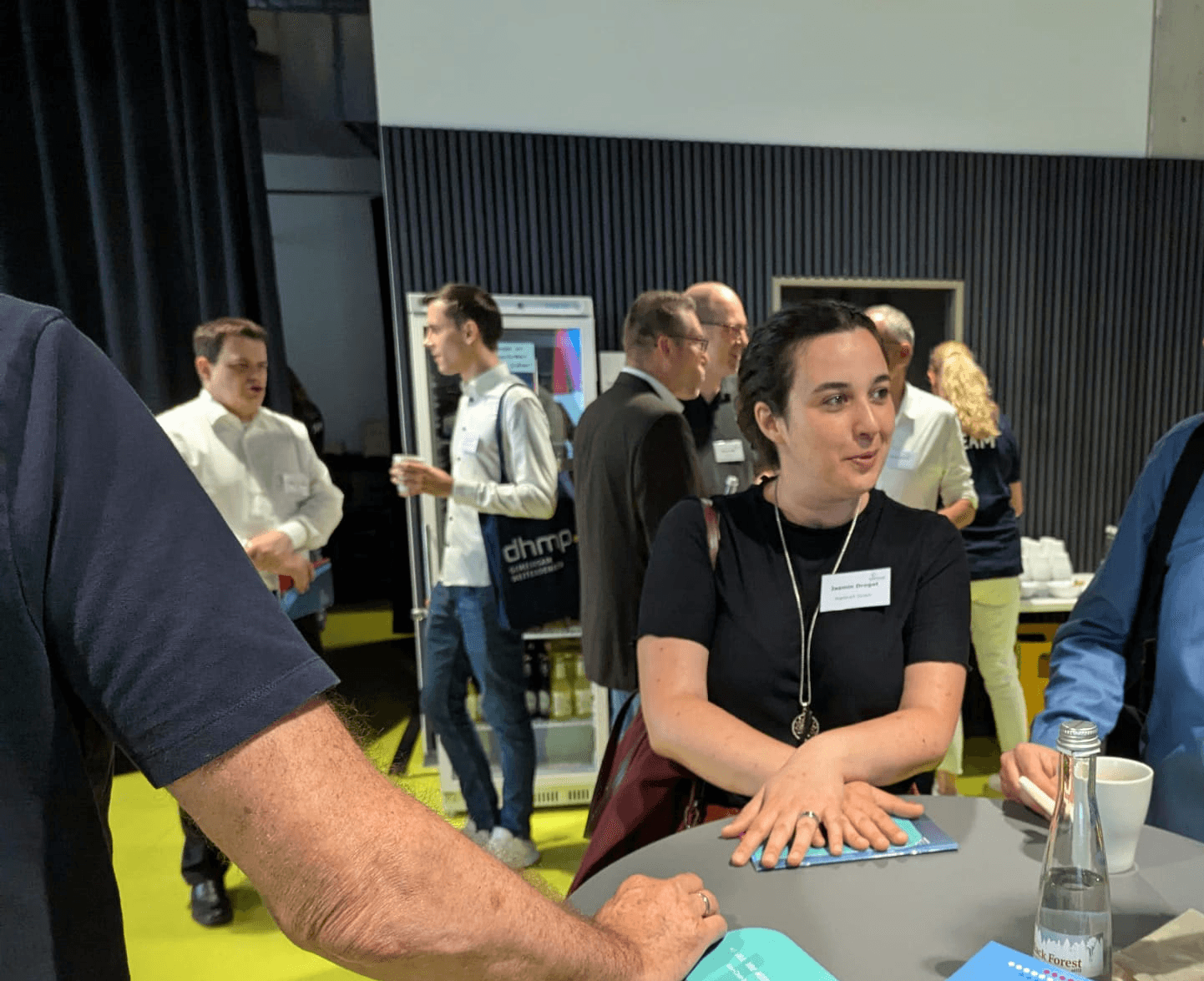 Eine Frau unterhält sich mit anderen Teilnehmern auf einem Event.