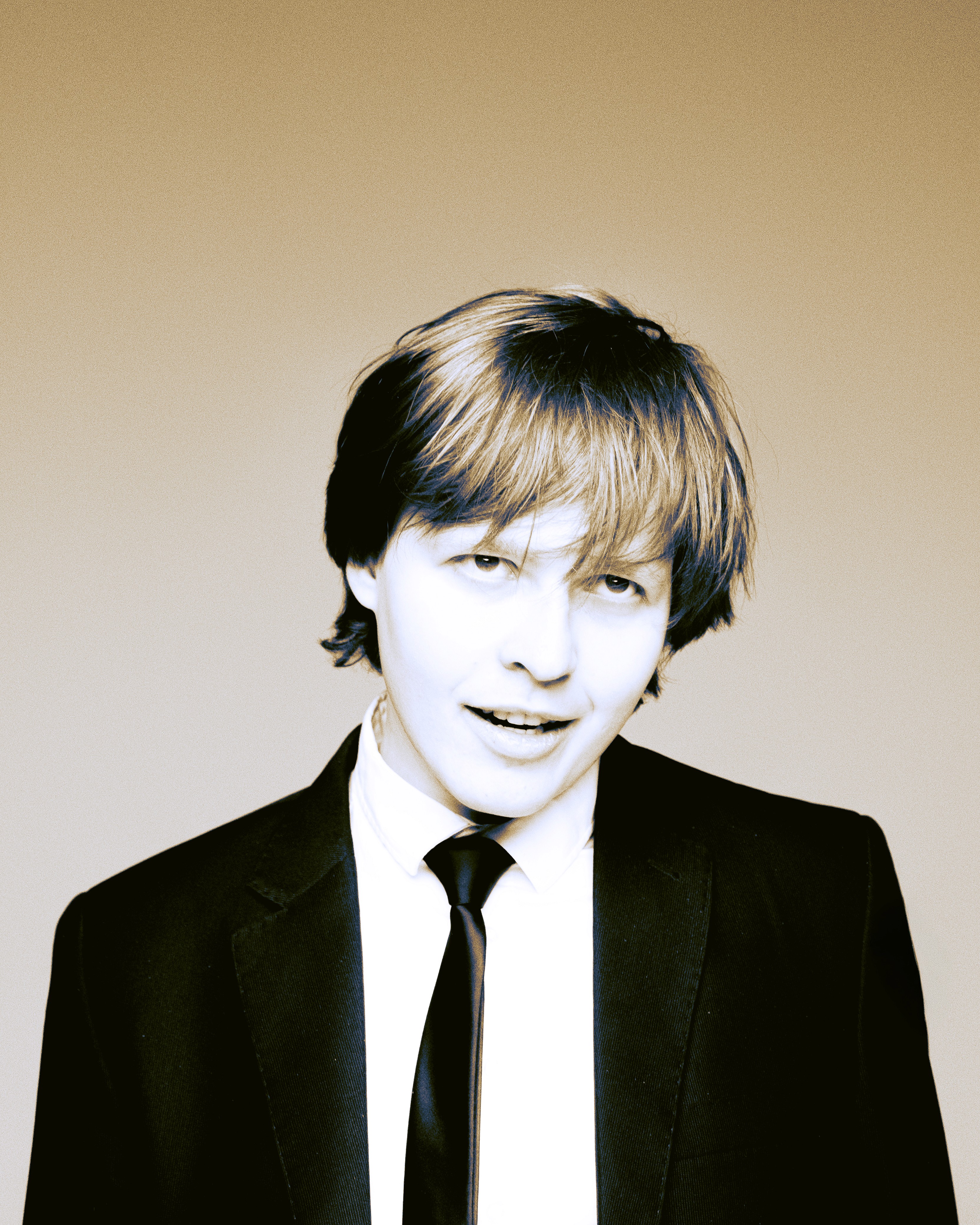 Rodion – Star Behavior – portrait in a suit with a playful, slightly mischievous expression