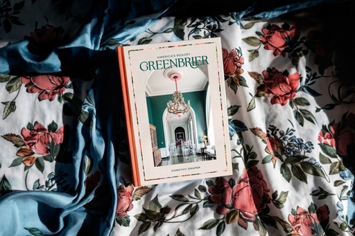 Greenbrier coffee table book resting on floral bed cover.