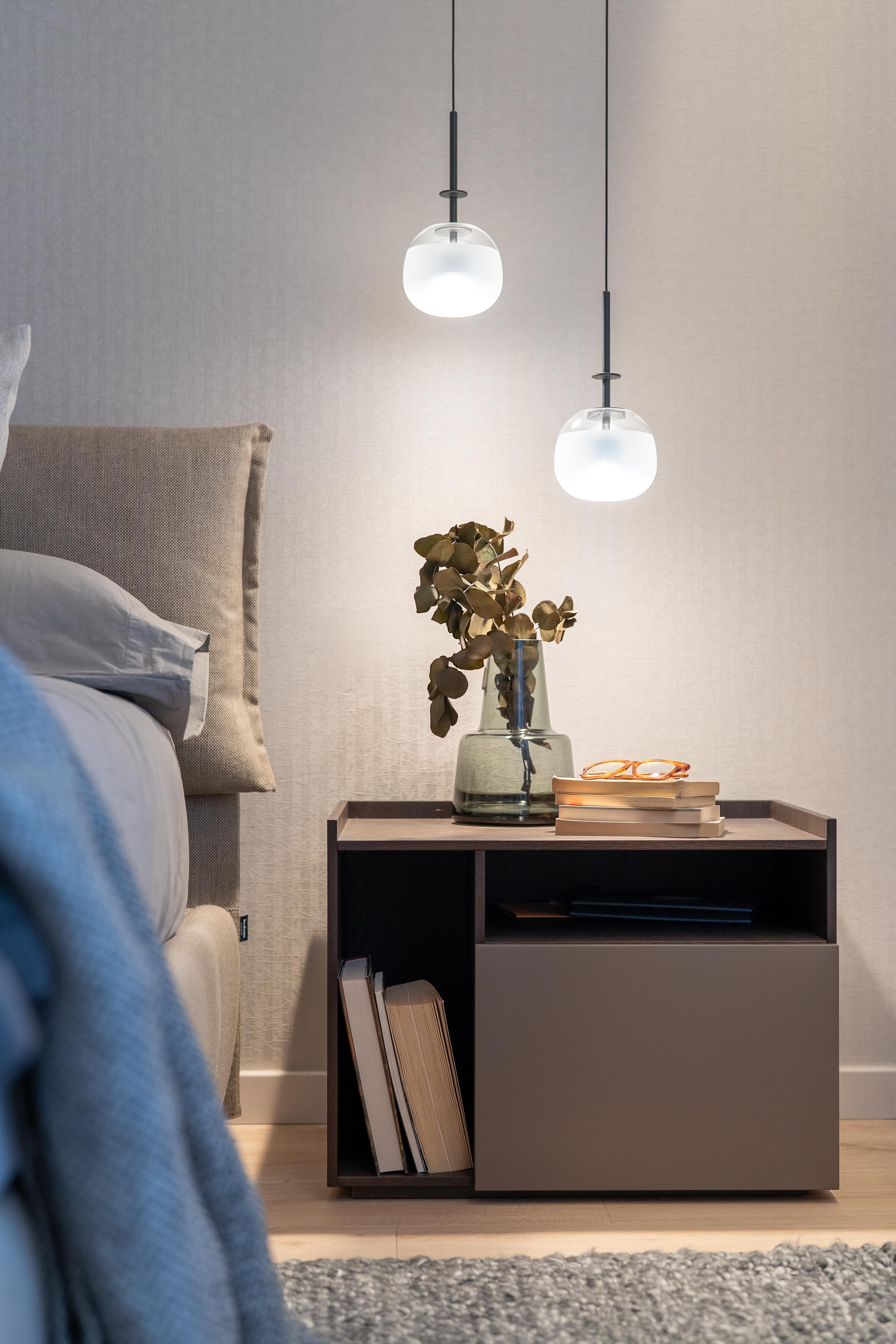 Detalle de mesita de noche con lámparas colgantes redondas