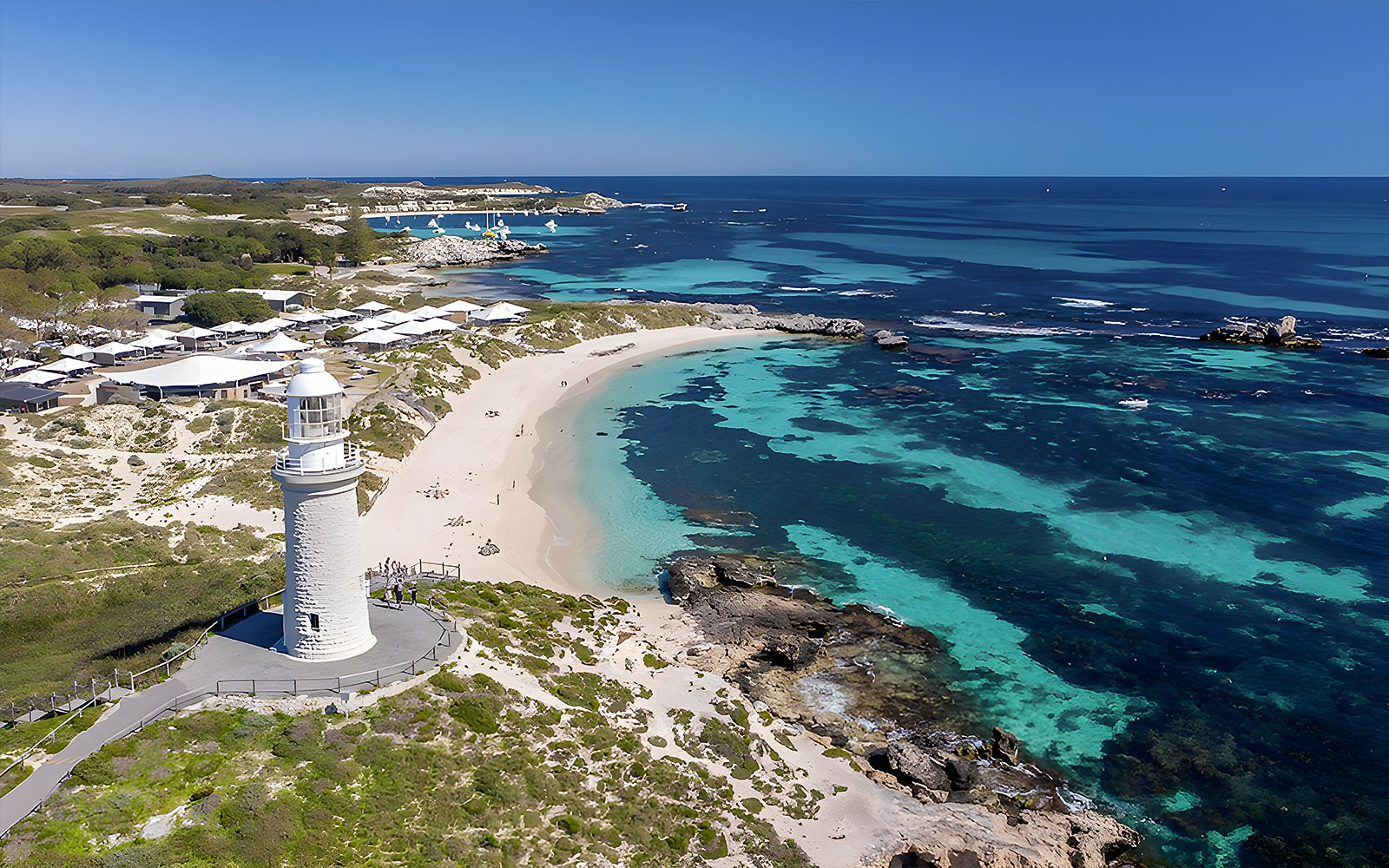 Rottnest Island coastline with lighthouse and turquoise waters, view from above.