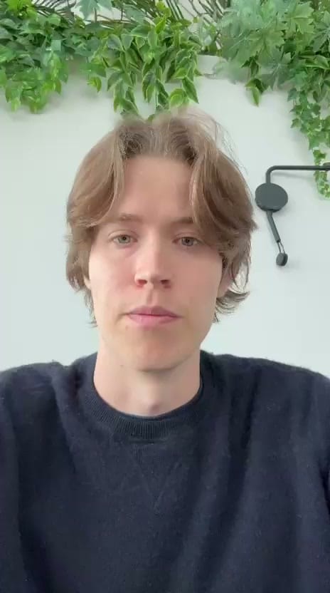 A man works on a laptop in an office.