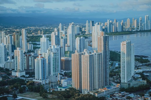 A modern skyscraper with a glass facade reflecting the setting sun's rays.