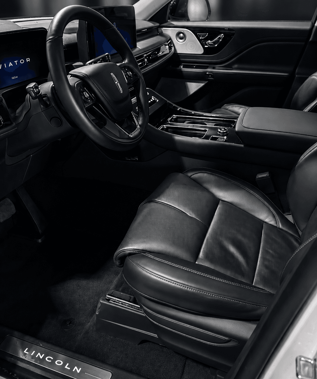 Interior of a luxury car with a leather steering wheel.