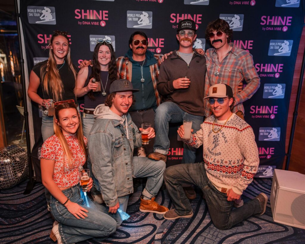 Group of guests posing in front of a Shine event backdrop