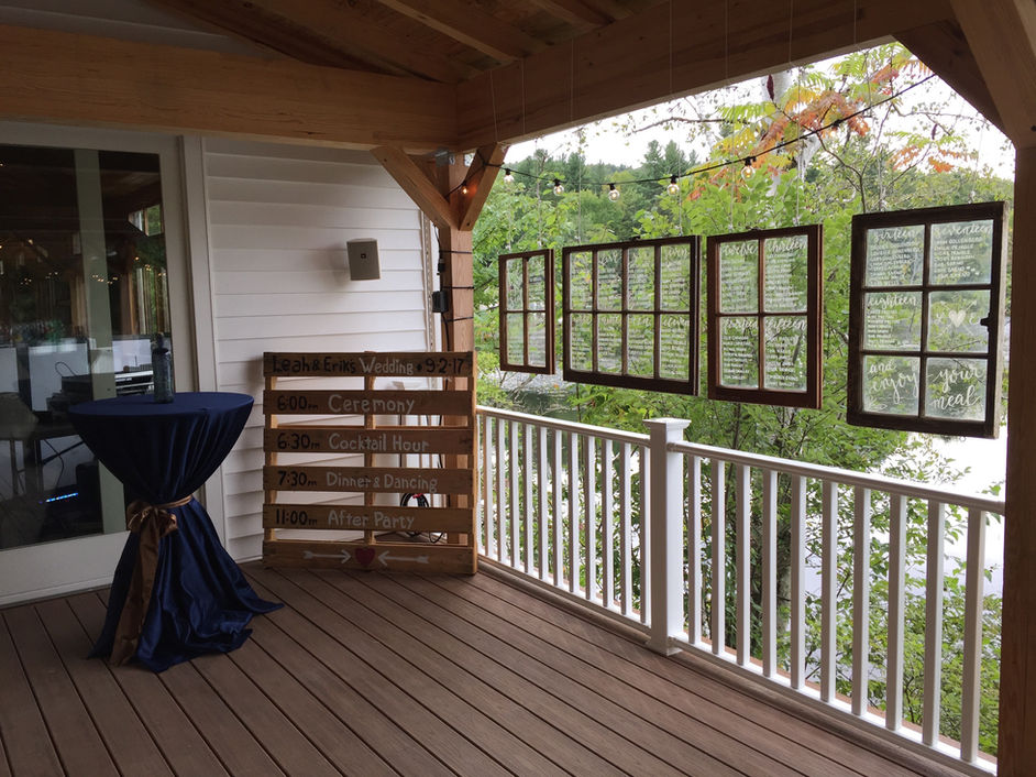 Covered porch with window seating chart and event schedule sign at Camp Lenox