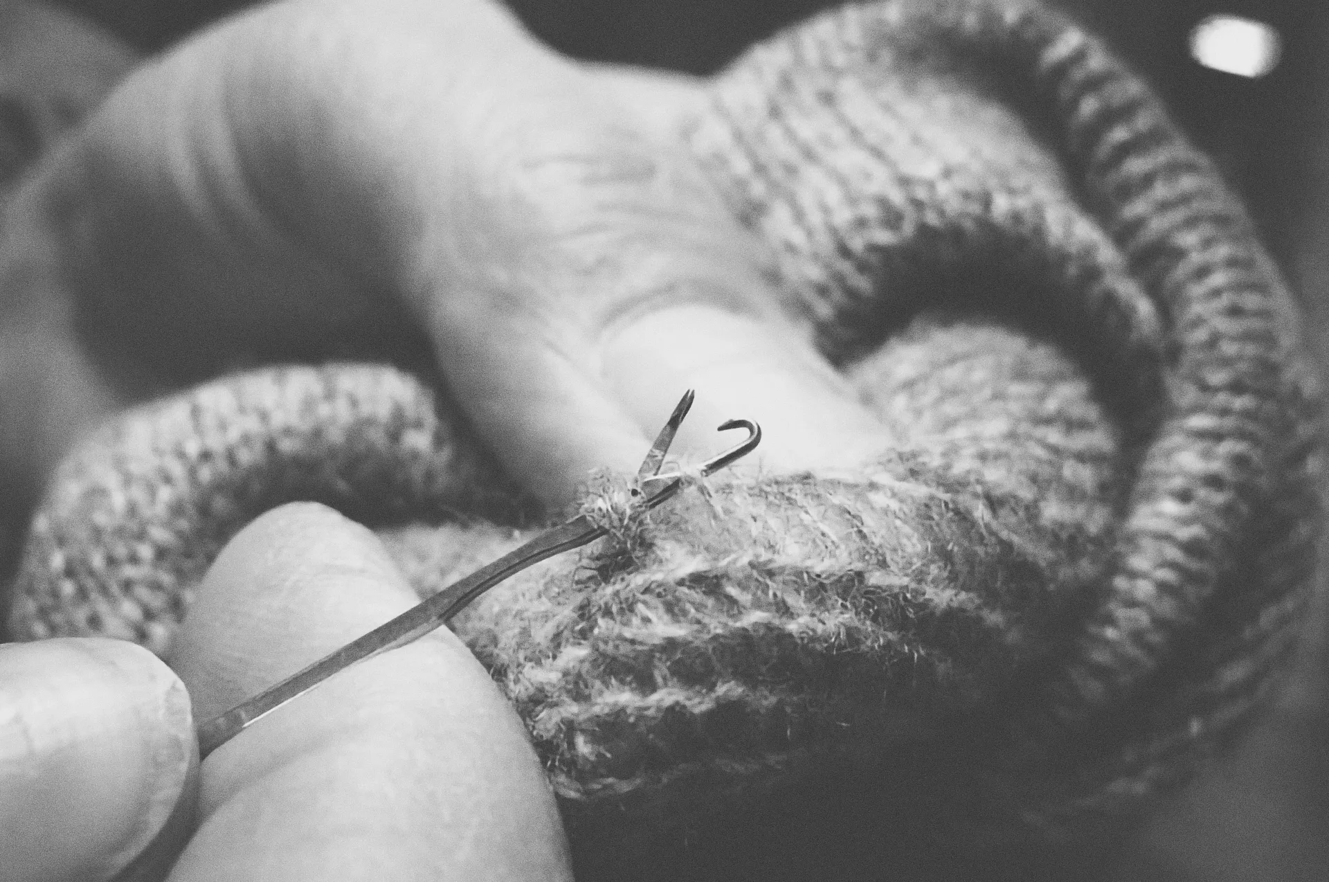 Artisan hand-finishing a cashmere sweater – meticulous detail of Aida Barni and Annapurna craftsmanship.