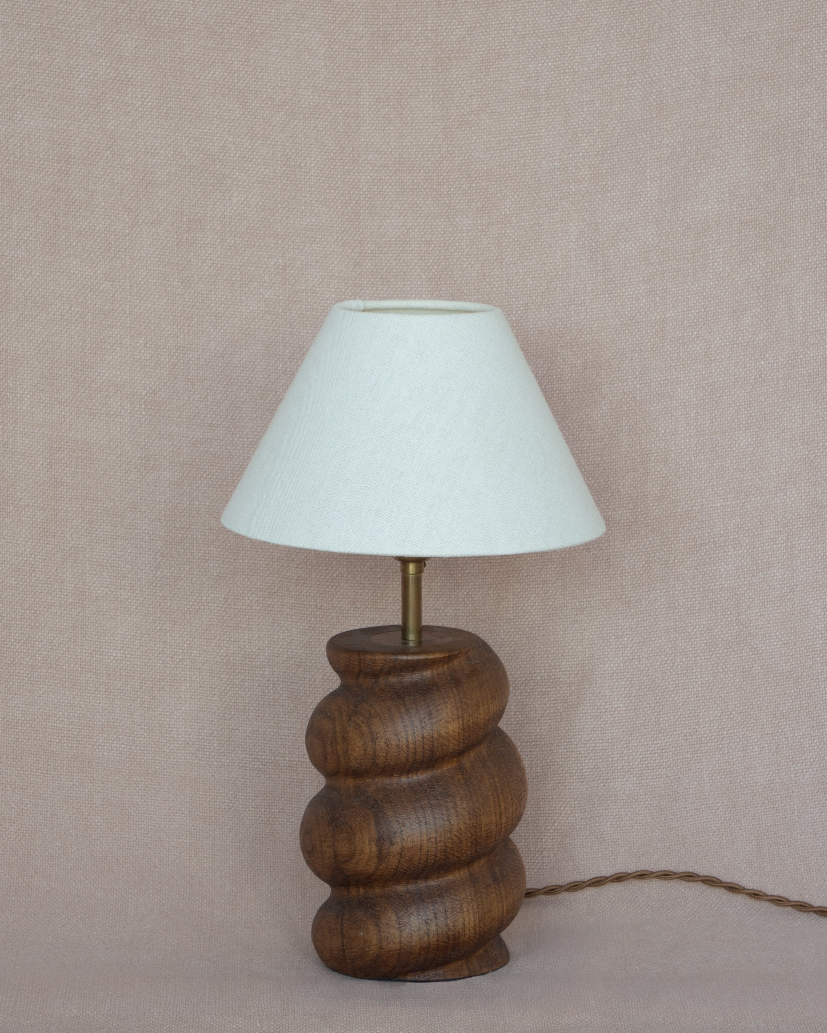 Caracol Table Lamp in Walnut against warm linen fabric