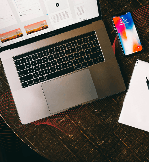 MacBook beside iPhone X on brown table