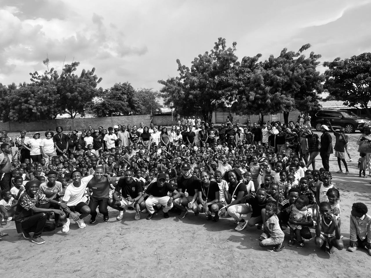 five children smiling while doing peace hand sign