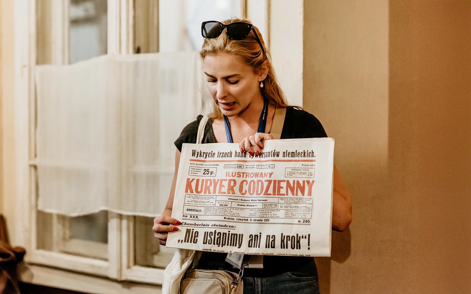 Leiðsögumaður með sögulegt dagblað í höndunum á meðan á ferð stendur í Oskar Schindler verksmiðjunni í Kraká.