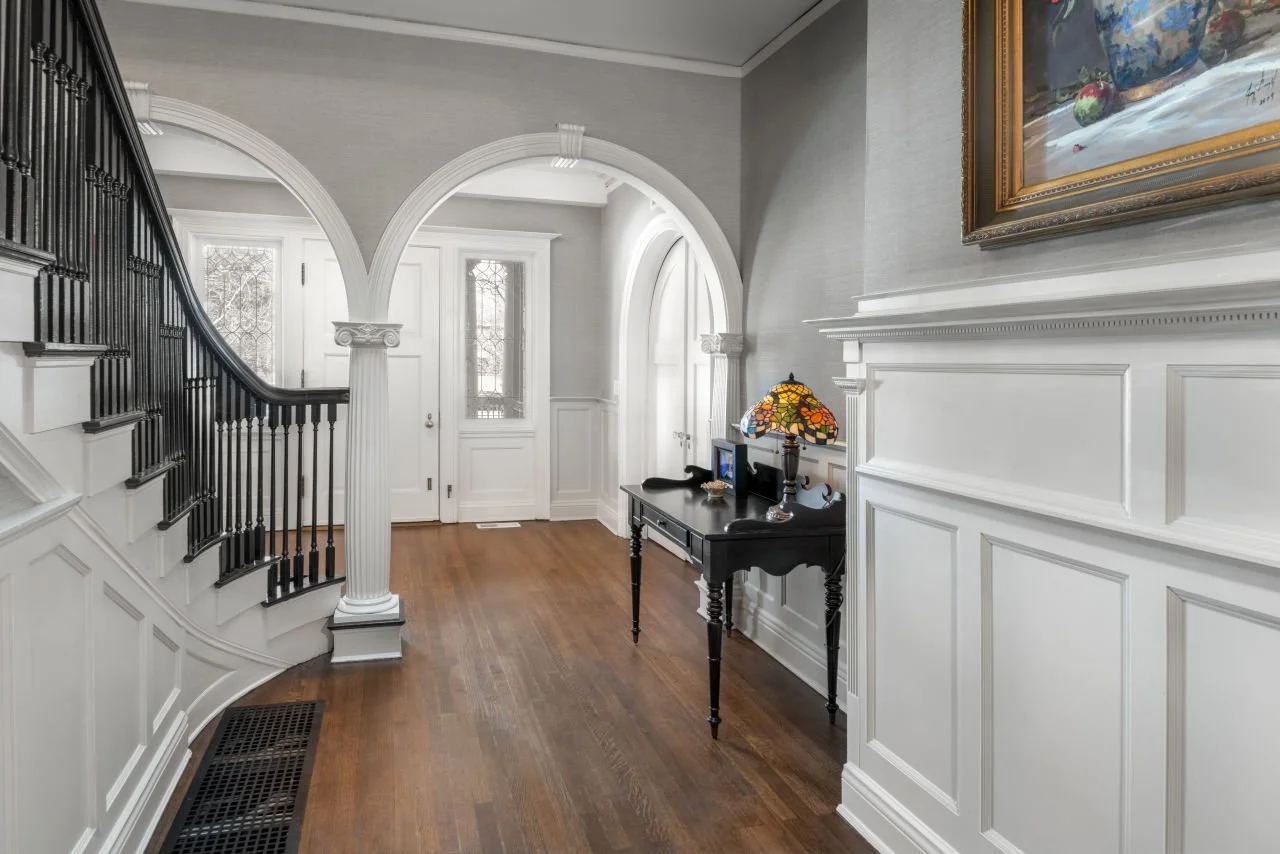 grand foyer with arched columns and wainscoting