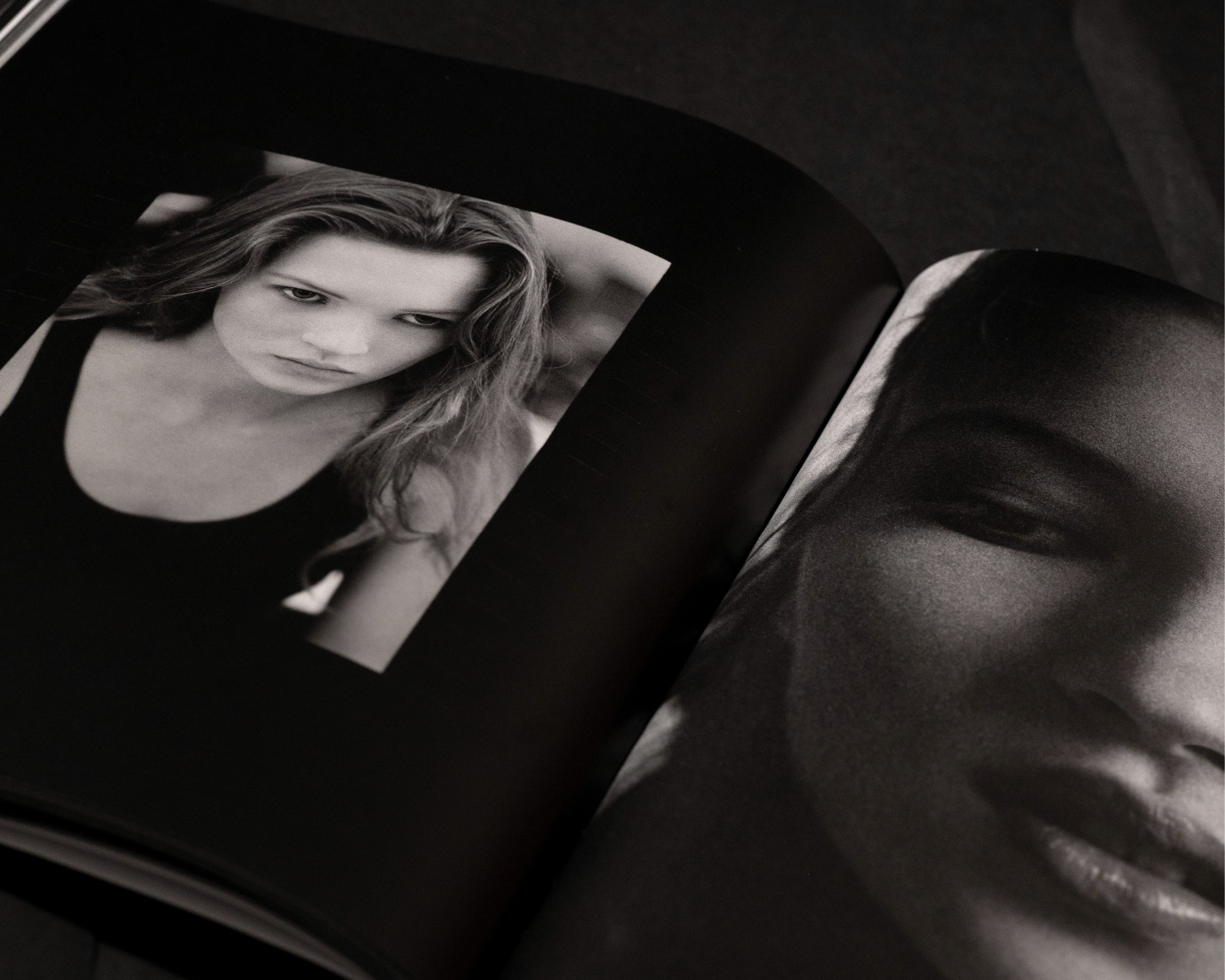 A close-up of an open magazine featuring two black-and-white portraits of Kate Moss, one showing a face and the other a profile.