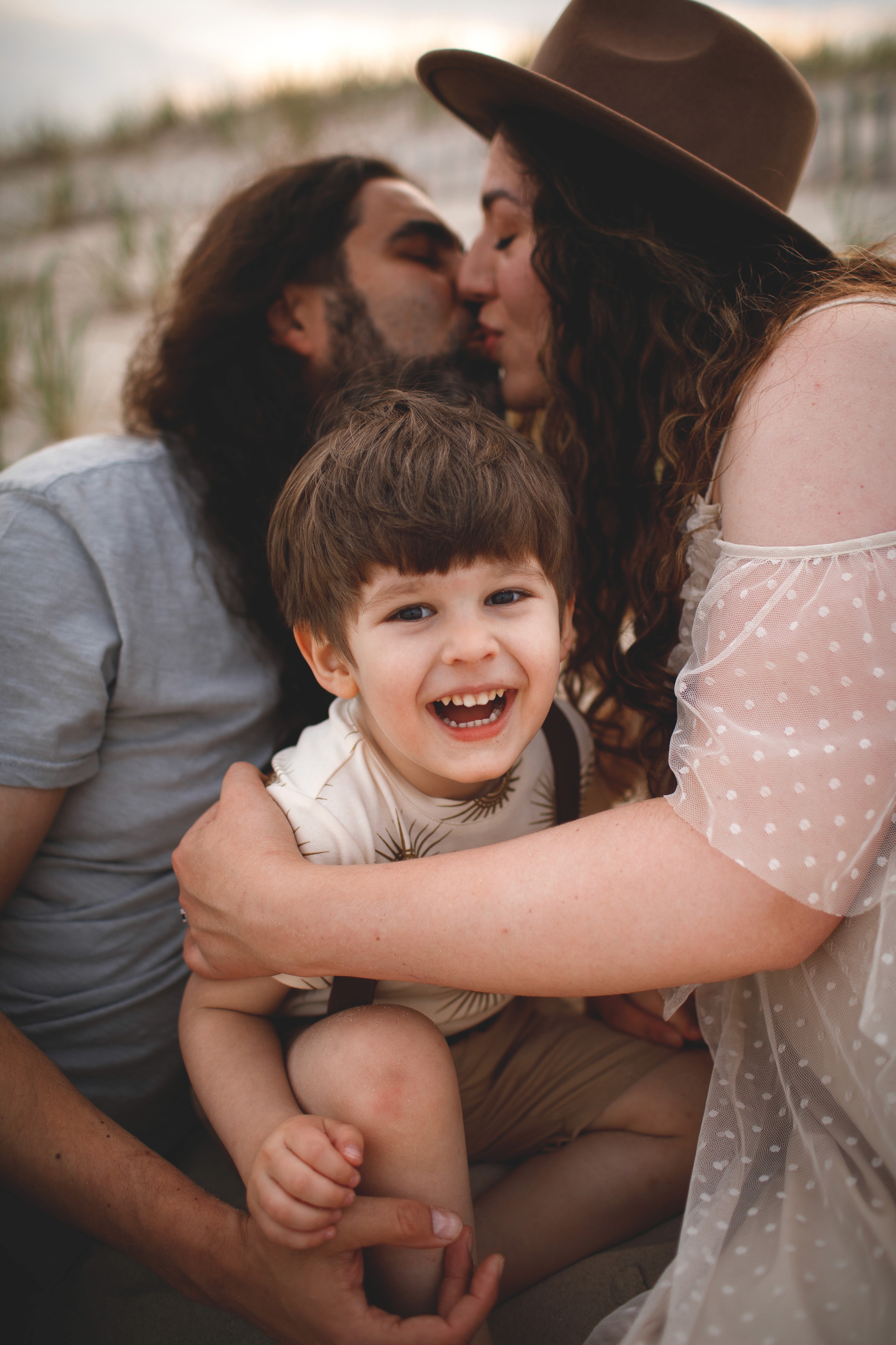 Parent holding a young child during a coastal family session in Encinitas.