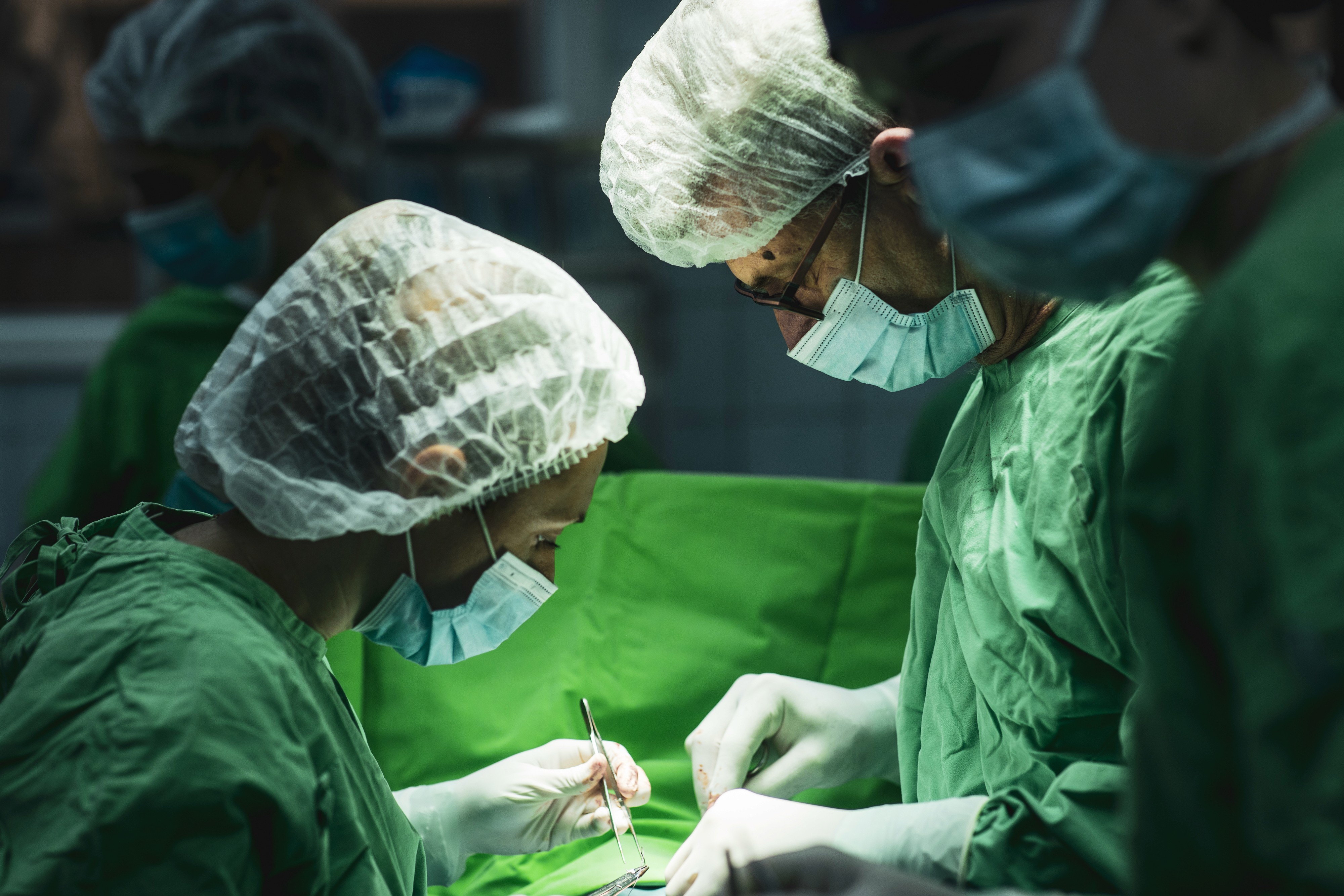 Műtő orvosok műtét közben felülről erősen megvilágítva.