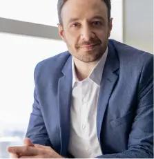 A man in a blue suit sitting in a chair