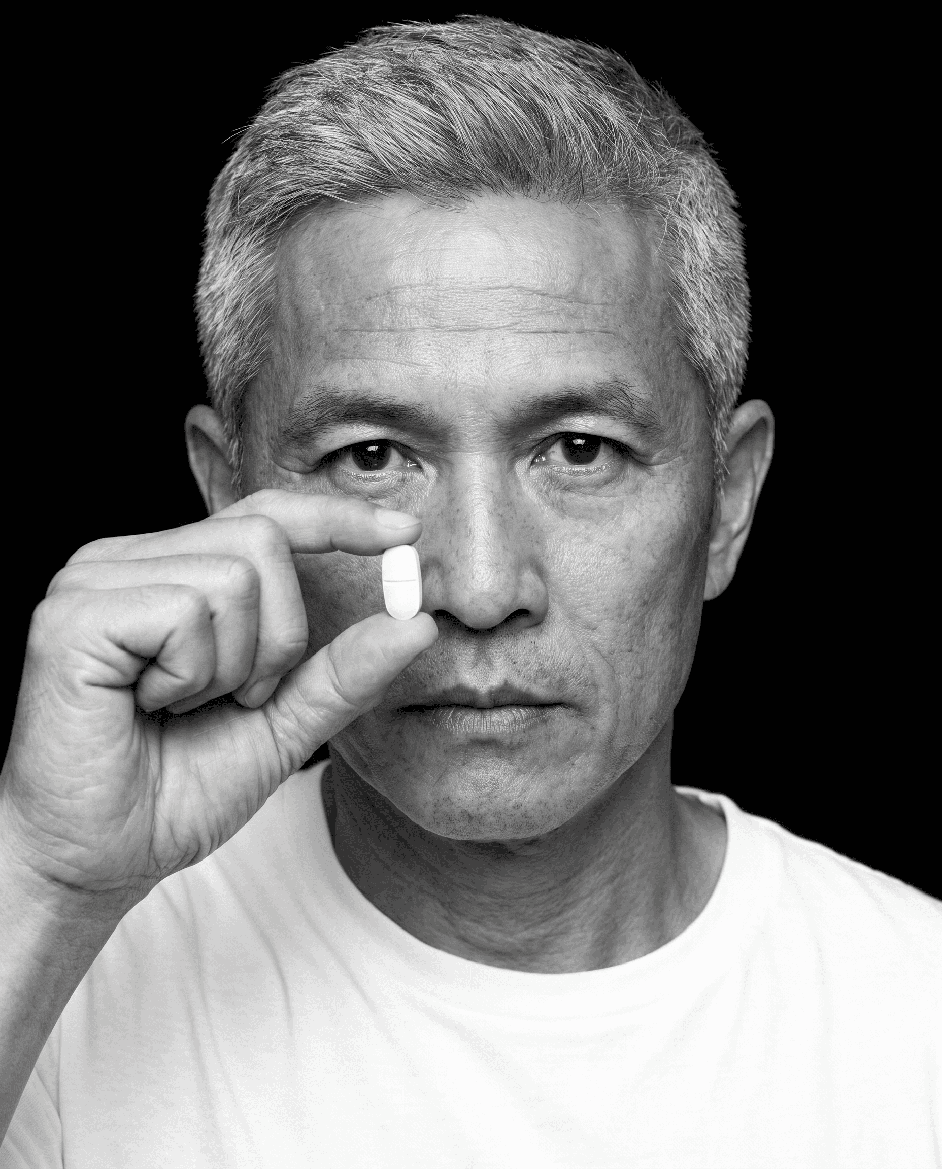 Portrait, black background flowing into a white shirt