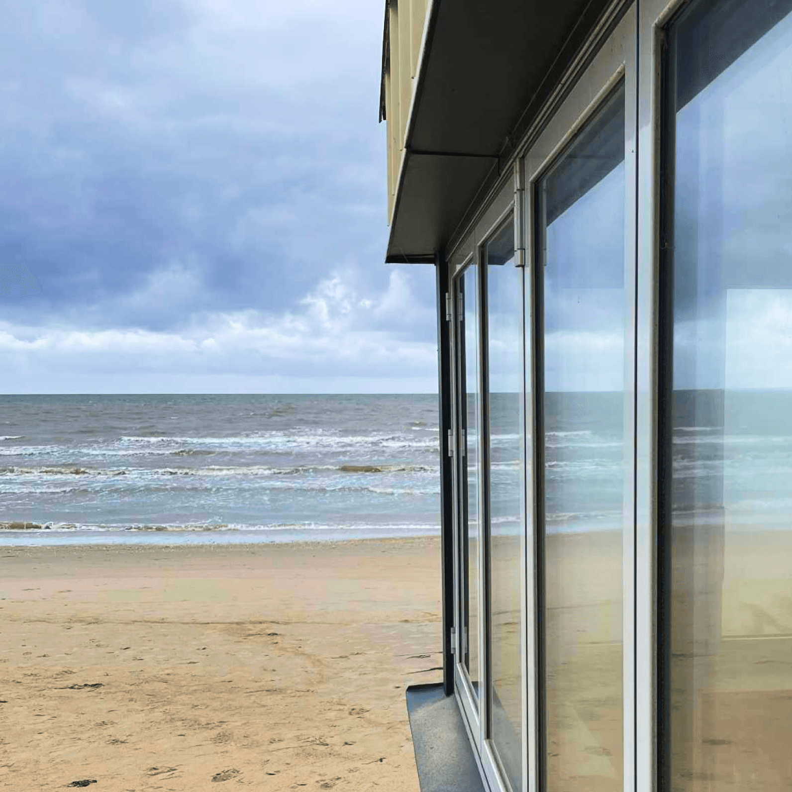 Bild på Skrea Strand och ett blänkande fönster