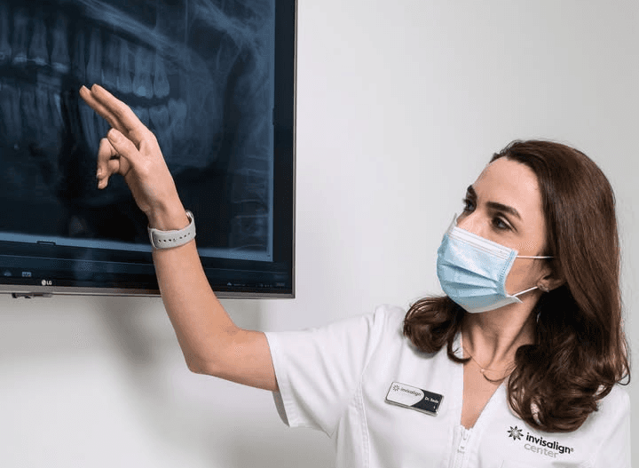 Dental professional discussing Invisalign® treatment technology to a patient.