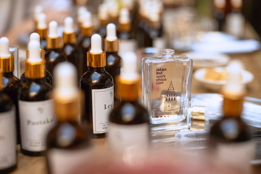 A close-up of various bottles and tools used in a perfume-making workshop, with focus on the different ingredients available for creating personalized fragrances.