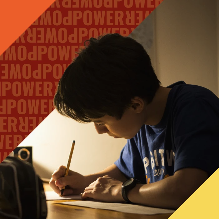 Little boy writing under dim lamp light
