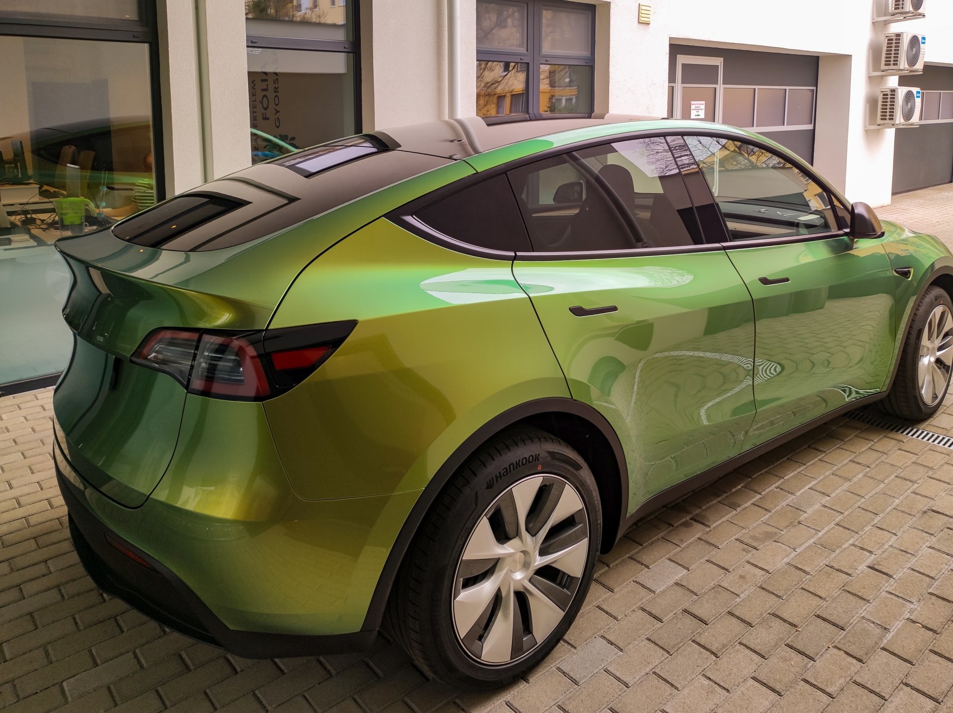 Tesla Model Y zöld kaméleon PPF Wrap karosszériavédő fóliával – szín és védelem egyszerre.