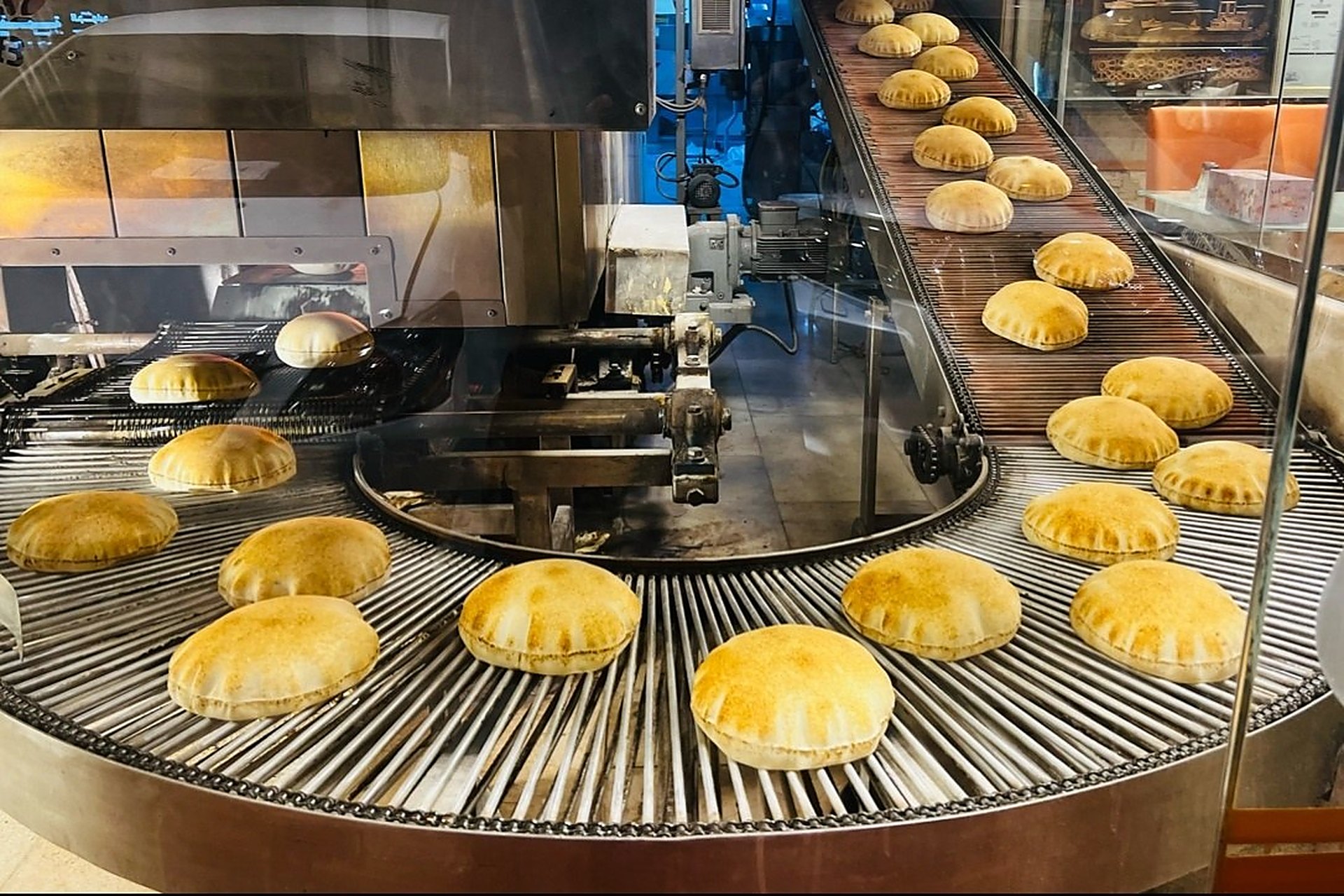 Des pains khubz qui sortent du four sur le tapis roulant d'une boulangerie de Doha, au Qatar, où le pain est mis à disposition gratuitement