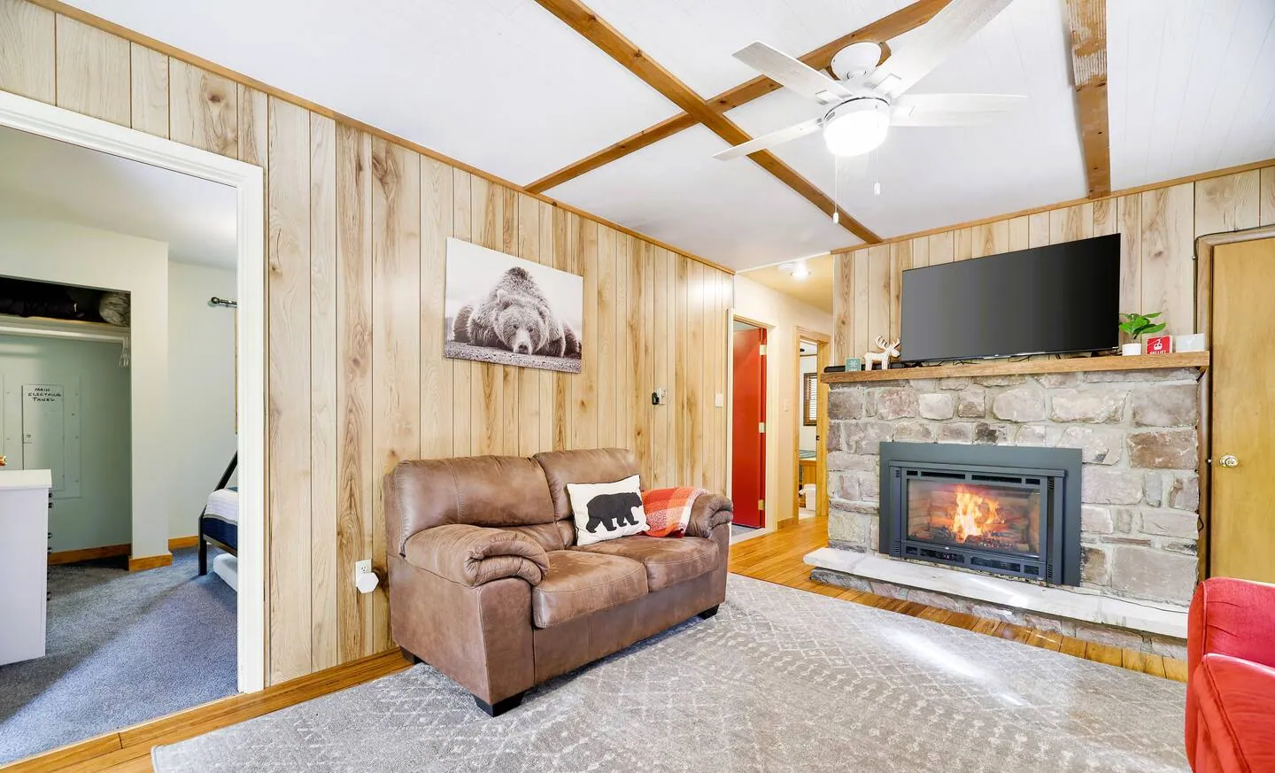 Lower family room with leather sofa, gas fireplace and TV at RedHawk Chalet