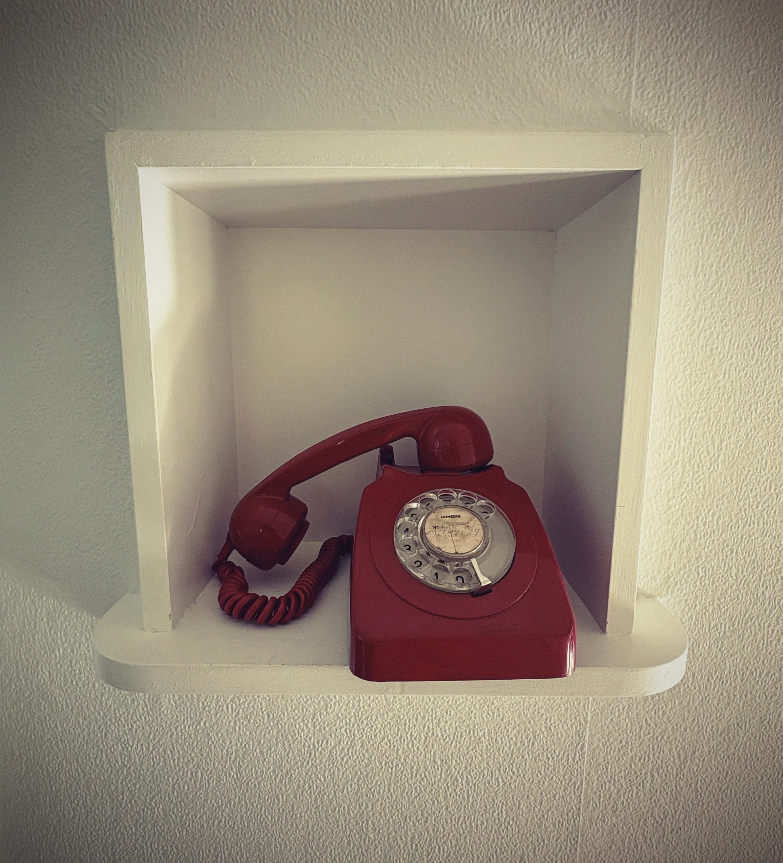 A close-up of a pink cocktail in a martini glass, set against a nighttime background with soft, blurred colors.
