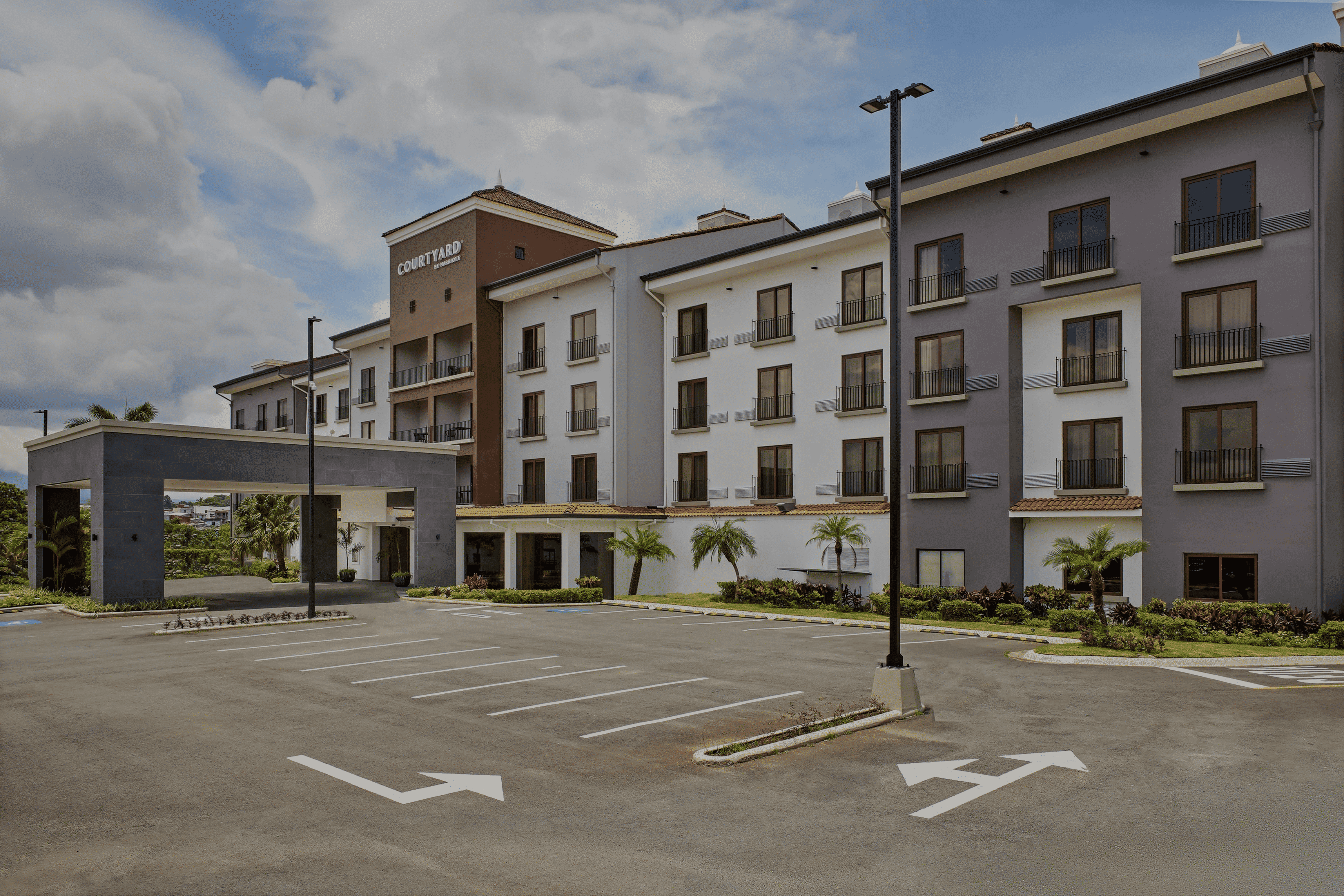 Fachada del hotel Marriott Courtyard Escazú con diseño contemporáneo y ventanales de gran formato.