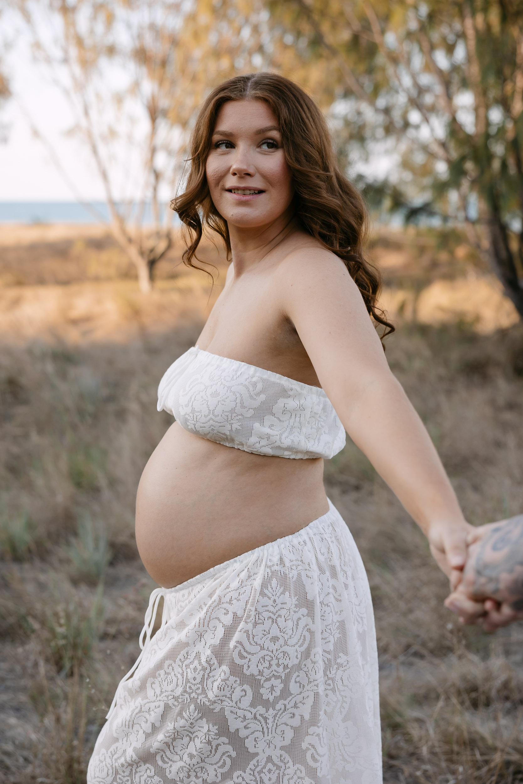 Maternity photography Mackay in open grass fields at sunset