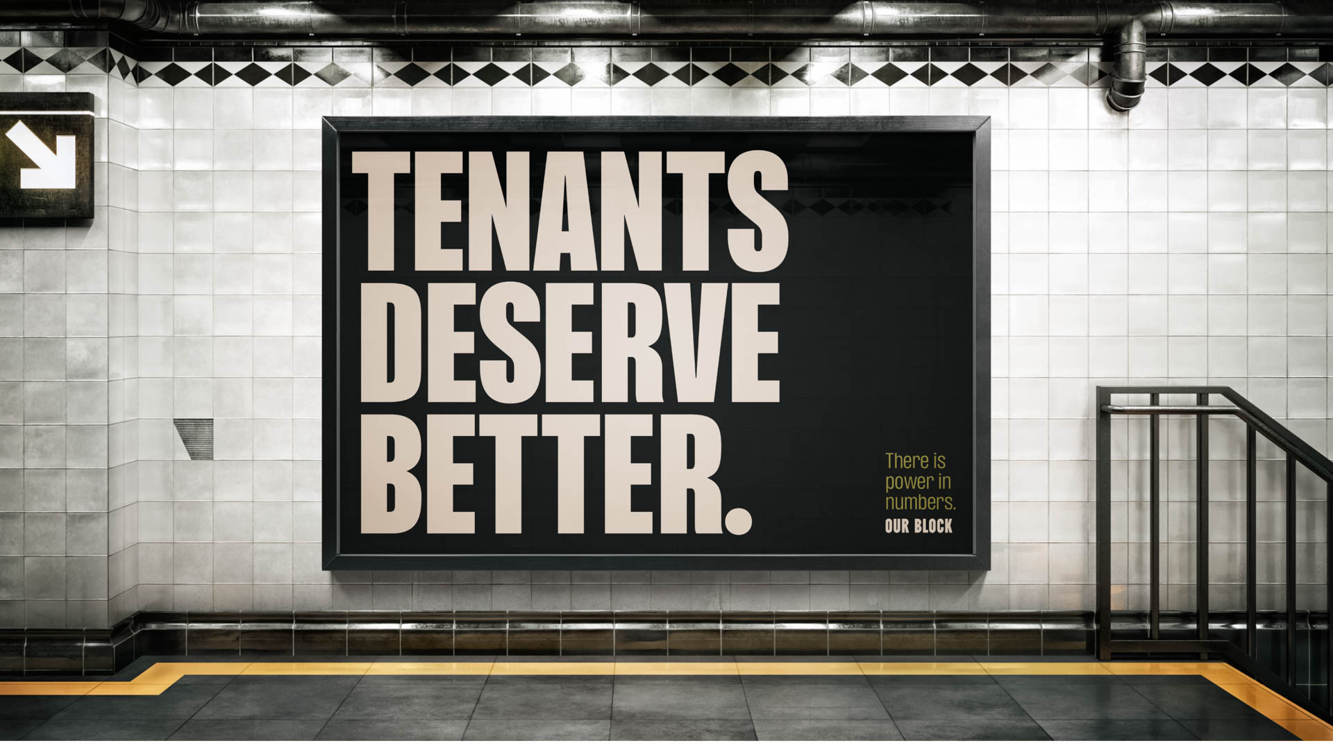 A large black sign with white text reading “TENANTS DESERVE BETTER.” is mounted on a white tiled wall. Below the statement, in smaller text, it reads, “There is power in numbers.” and “OUR BLOCK.” A black metal railing is visible to the right of the sign. The floor is dark gray with yellow lines along the edge.