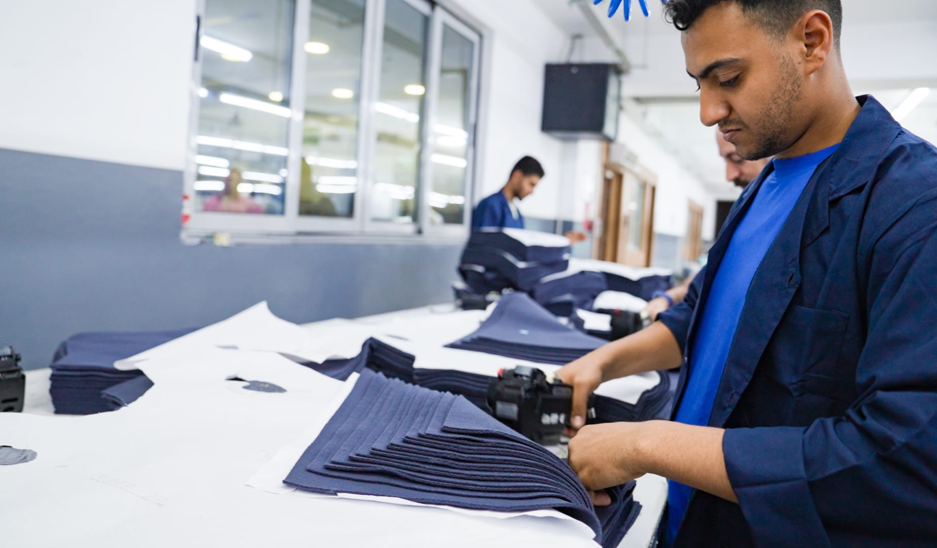 Worker with fabric pieces.