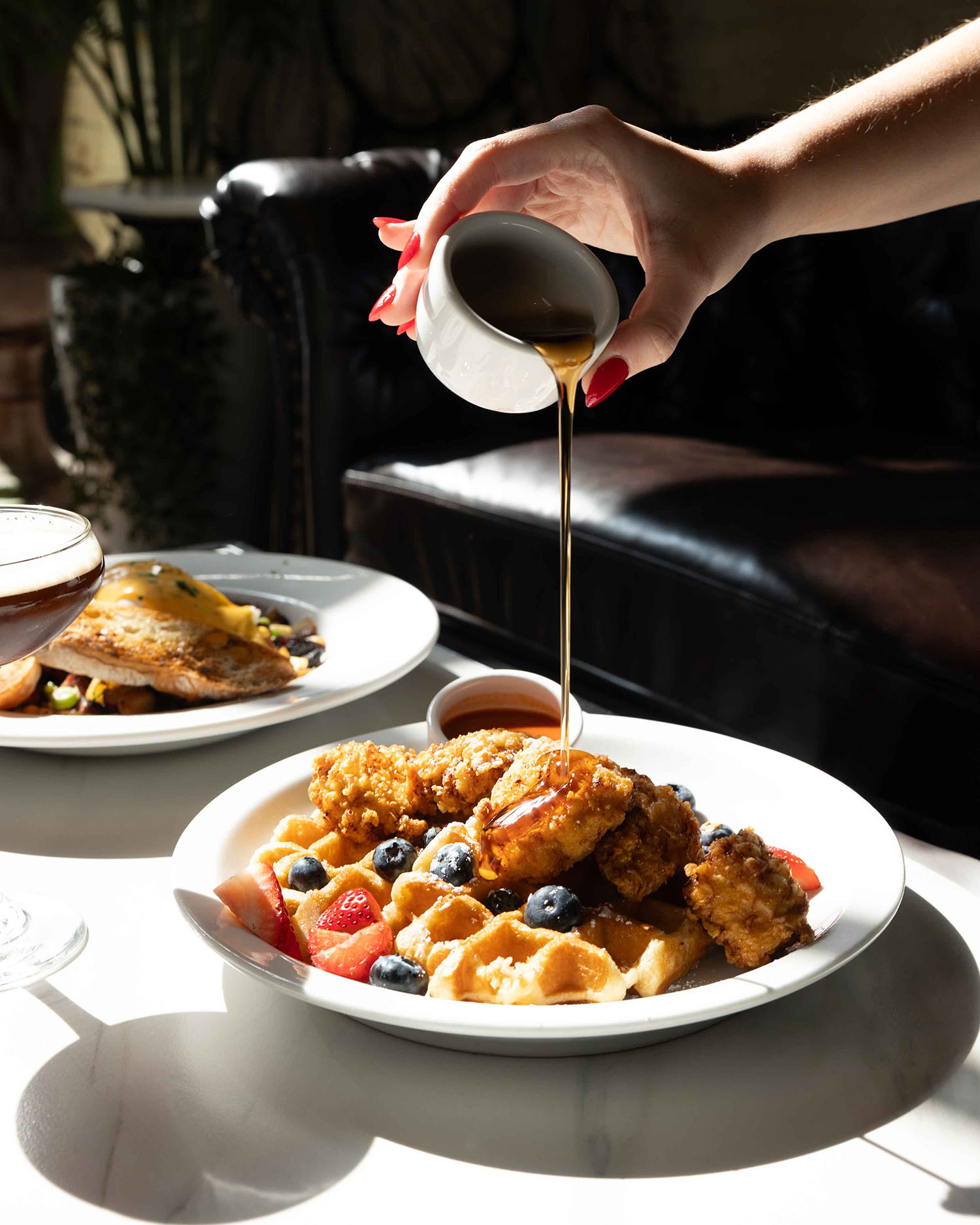 Syrup being poured over waffles and brunch dishes at Hubbard Inn in River North Chicago IL