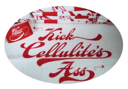 white fabric piece with the curvy typeface message kick cellulite's ass