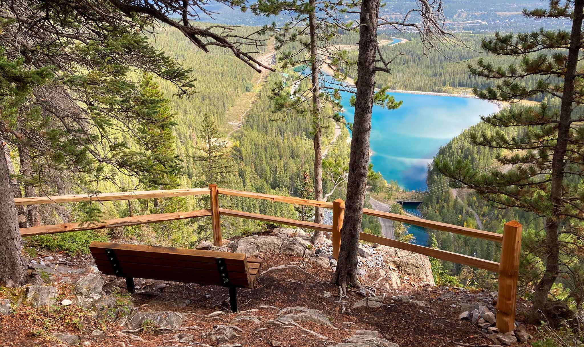 Trail viewpoint with bench and safety railing overlooking Grassi Lakes in Canmore area